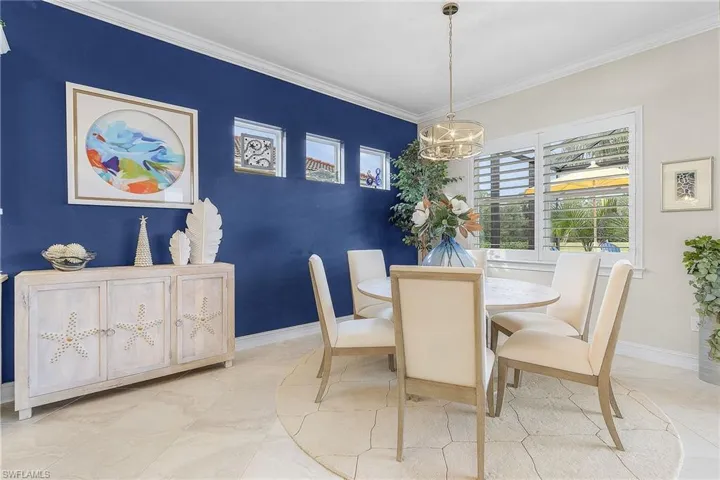 Tiled dining room with crown molding and a notable chandelier