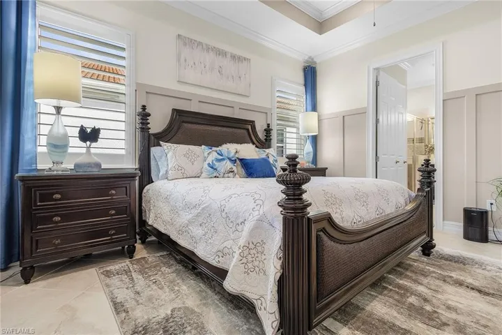 Tiled bedroom with crown molding and ensuite bath