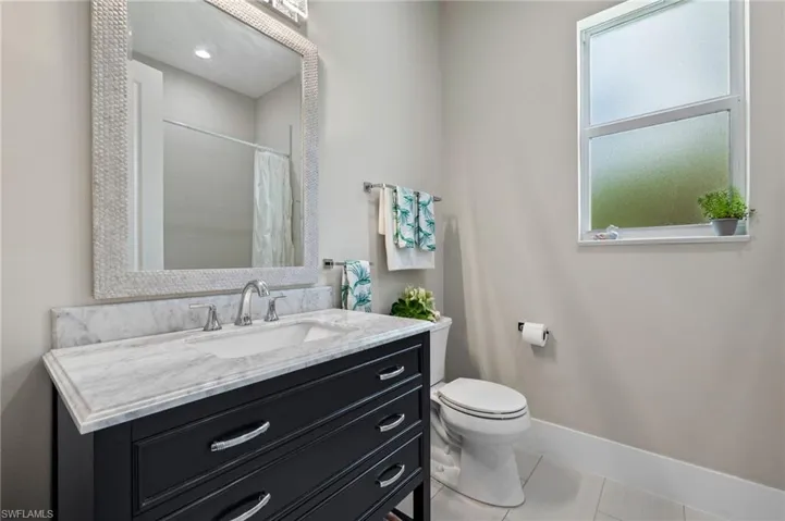 Bathroom with vanity, toilet, and tile floors