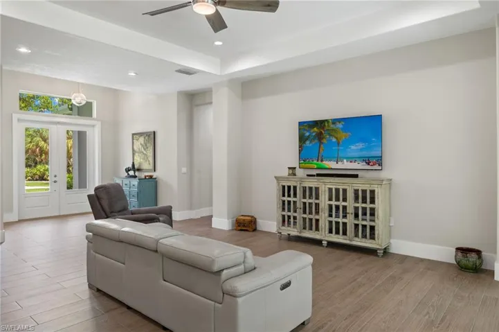 Living room with ceiling fan, french doors, and light hardwood / wood-style flooring