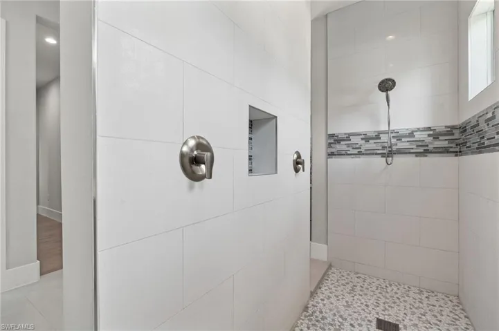 Bathroom with tiled shower and tile floors