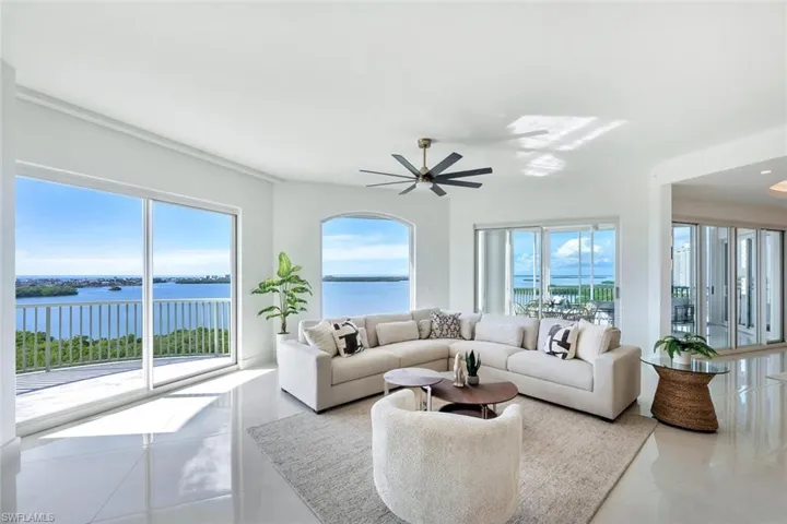 Family room featuring  water view, ceiling fan, and porcelain flooring