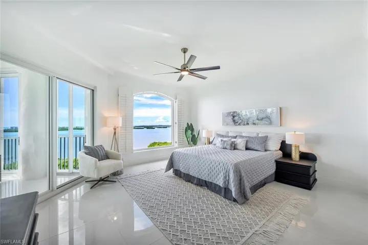 Master ensuite featuring expansive water views, ceiling fan, and access to the lanai
