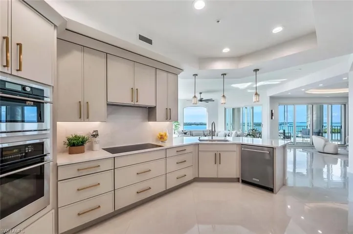 Kitchen featuring tray ceiling, open floor plan, recessed lighting, and appliances with stainless steel finishes