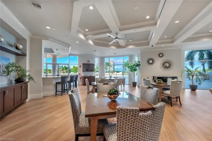 Community room on the 2nd floor with game tables, tv, library, kitchen and bar and large walk out patio