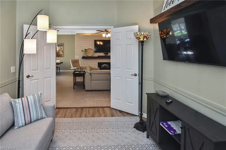 Living room featuring light tile patterned floors and a ceiling fan
