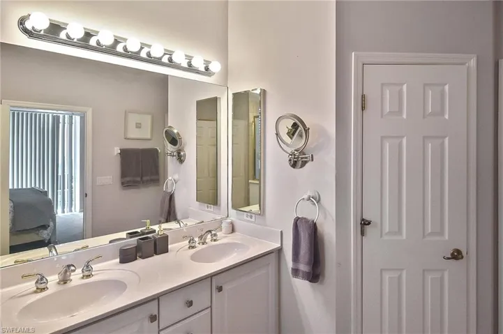 Full bath featuring double vanity and connected bathroom