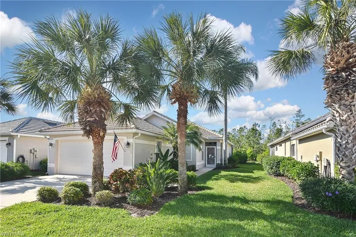 View of home's exterior with stucco siding, a lawn, a garage, and driveway