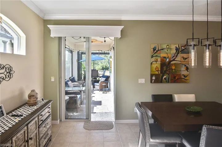 Dining space with crown molding and light tile patterned floors