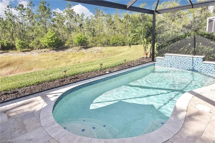 Outdoor pool featuring a lanai, a lawn, and a sunroom