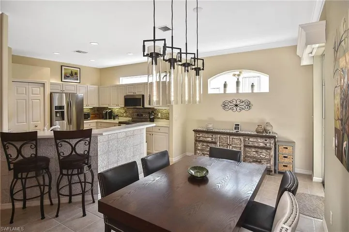 Dining area featuring light tile patterned flooring and recessed lighting