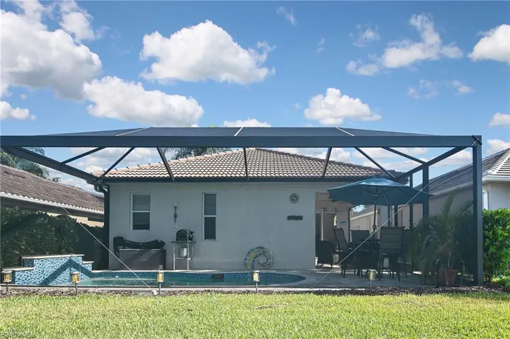 Back of house with a sunroom, glass enclosure, and a patio