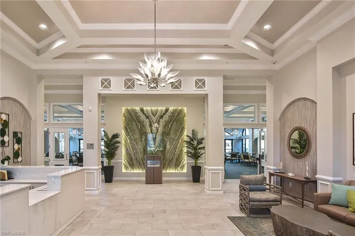 Building lobby featuring a towering ceiling, beam ceiling, ornamental molding, and coffered ceiling