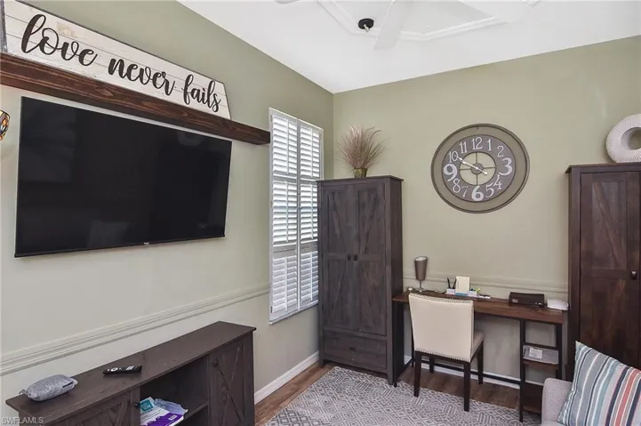 Office space with dark wood-type flooring and a ceiling fan