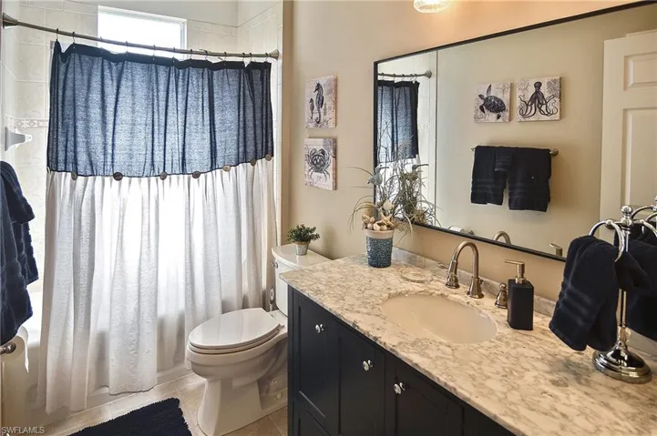 Full bath featuring vanity, shower / bath combination with curtain, and light tile patterned flooring