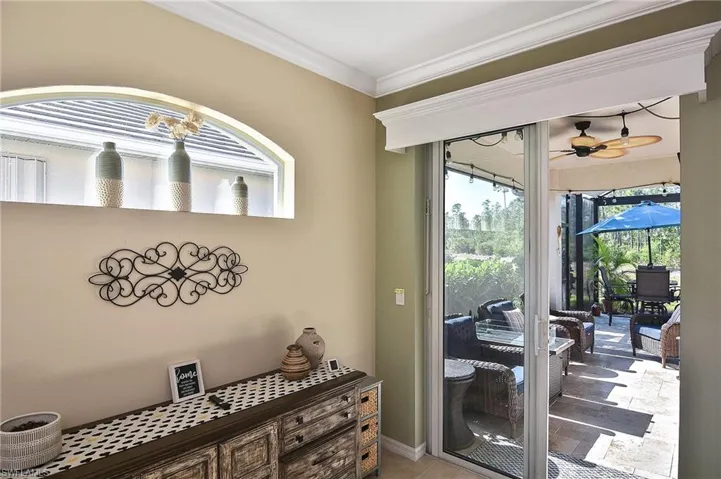 Entryway featuring crown molding, a sunroom, and a ceiling fan
