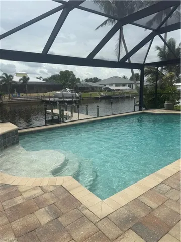 Swimming pool featuring a lanai, a boat dock, and a water view