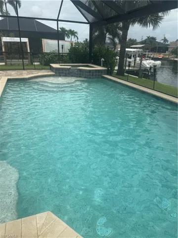 View of swimming pool featuring a lanai and a pool with connected hot tub
