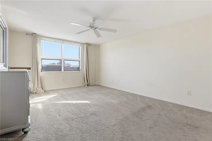 Spare room featuring carpet and ceiling fan