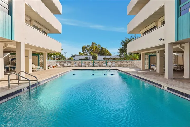 Community pool with a patio area and a balcony