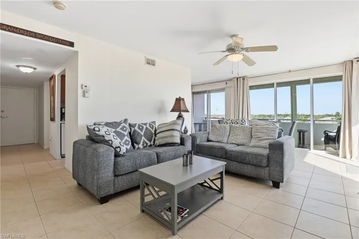 Living area with light tile patterned floors and ceiling fan