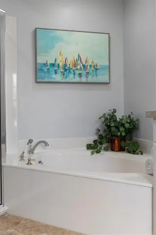 Bathroom with tile patterned flooring and a tub