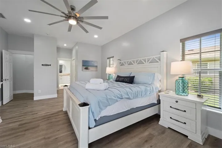Bedroom featuring connected bathroom, ceiling fan, and dark wood-type flooring