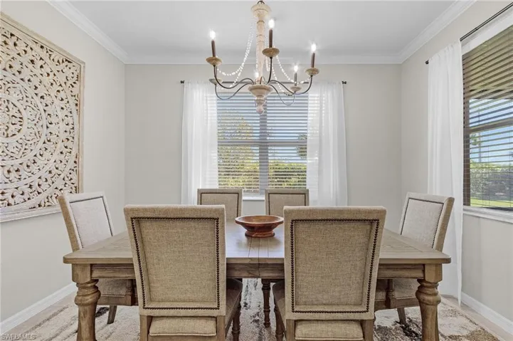 Dining room featuring crown molding, a notable chandelier, and baseboards