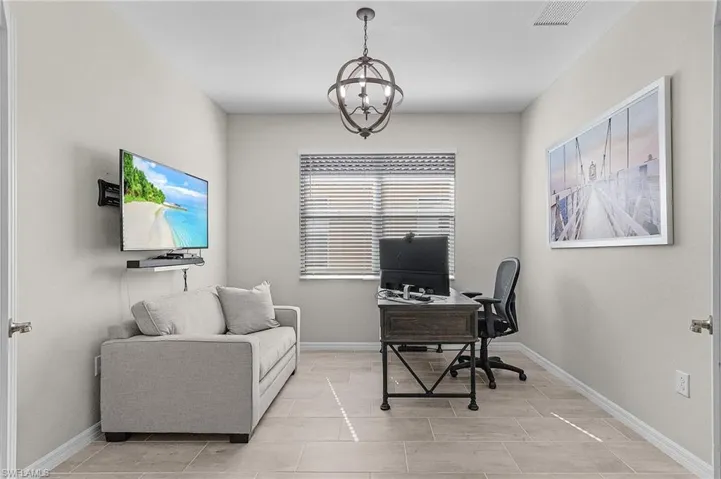 Office area featuring visible vents, baseboards, and an inviting chandelier