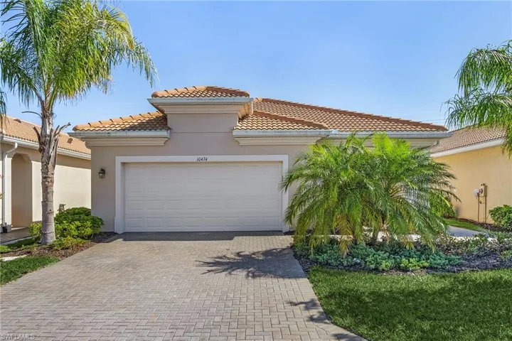 Mediterranean / spanish-style home with stucco siding, a tiled roof, decorative driveway, and a garage