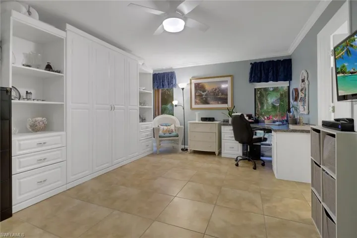 Tiled office space with ceiling fan and ornamental molding