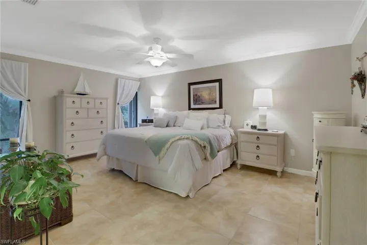 Bedroom with ceiling fan and ornamental molding