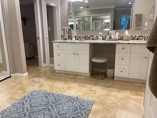 Bathroom featuring ornamental molding and vanity