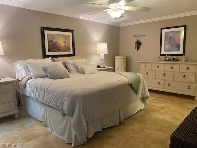 Bedroom with ceiling fan and ornamental molding