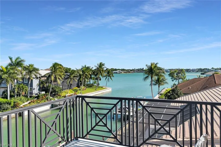Balcony featuring a decorative black metal railing and expansive water frontage