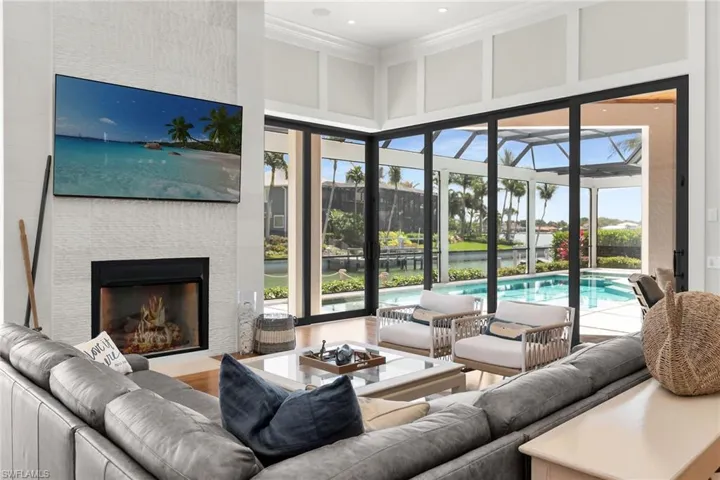 Living room featuring a tiled fireplace, wood-finish flooring, and expansive sliding glass doors
