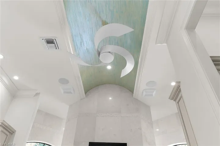 Sculptural ceiling fan set against an arched, textured ceiling panel