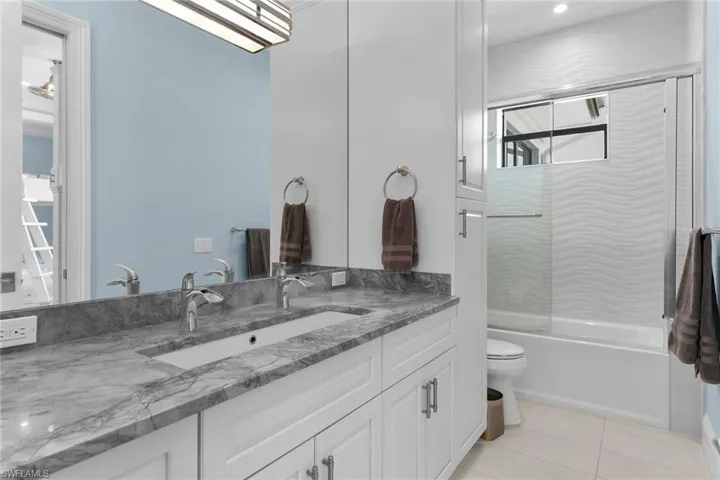 Double vanity with a stone countertop, dual undermount sinks, and chrome fixtures