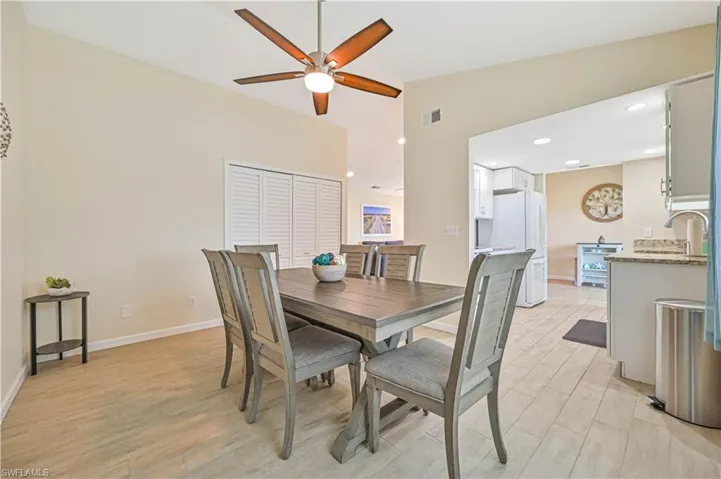 Dining area featuring light wood finished floors, a ceiling fan, recessed lighting, and lofted ceiling