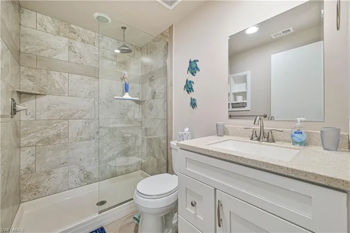 Full bath with vanity and tiled shower