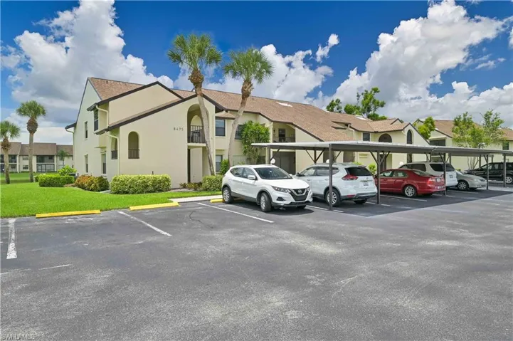 Partially covered parking lot featuring a residential view