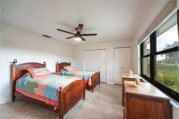 Guest bedroom #3 features tiled flooring, double closets, large impact windows with views to the back bay across the street and an en-suite bathroom.