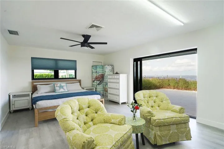 Primary bedroom with sitting area and pocketing impact glass sliders