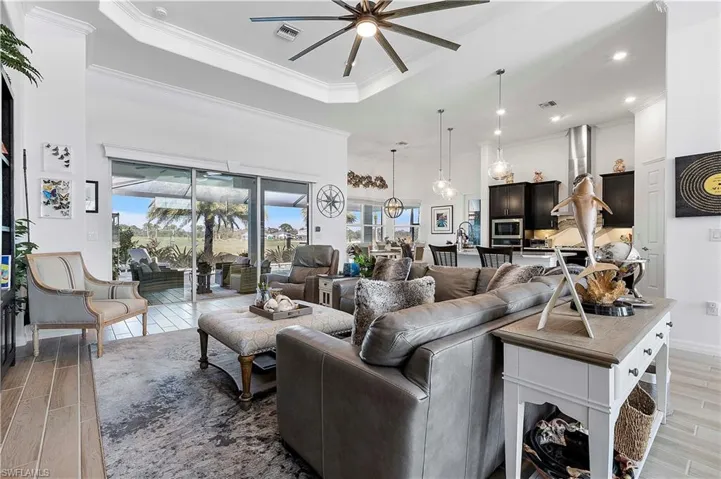 Living area with a wealth of natural light, visible vents, ceiling fan, and wood tiled floor
