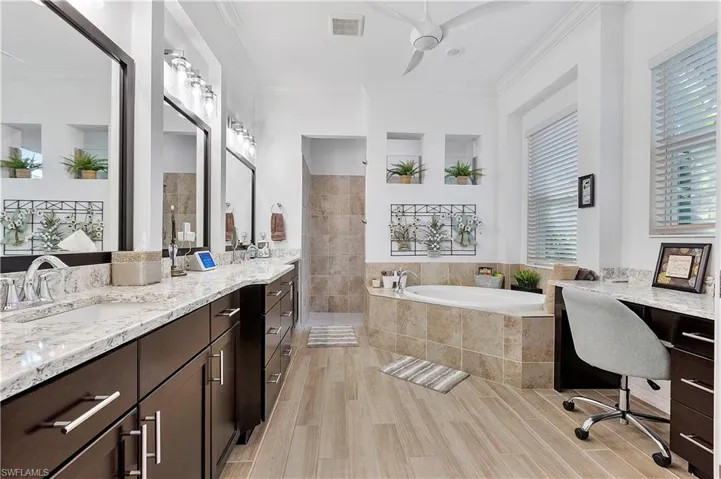 Bathroom featuring visible vents, wood tiled floor, ornamental molding, a walk in shower, and a garden tub