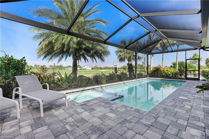 View of swimming pool with a patio area, a pool with connected hot tub, and a lanai