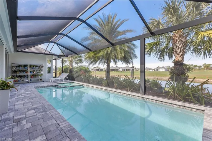 View of pool with a patio, a pool with connected hot tub, and a lanai
