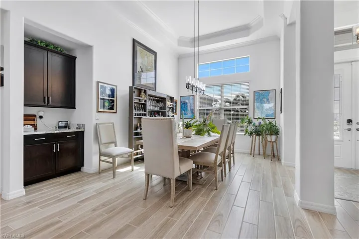 Dining room featuring crown molding, baseboards, and wood tiled floors