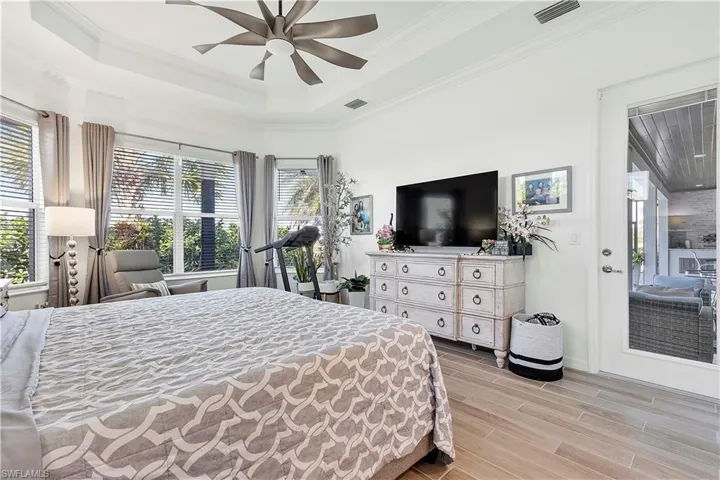 Bedroom with multiple windows, and wood tiled floor