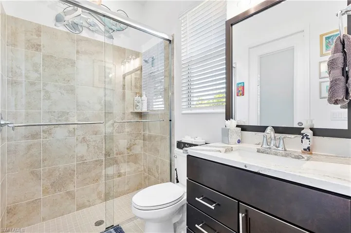 Full bathroom featuring vanity, toilet, and a stall shower